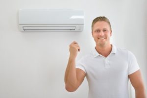 Man Standing Beside Ductless Mini Split System