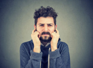 Man Puts Fingers In Ears To Block Out Noise