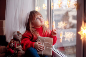 Little Girl Sitting By The Window